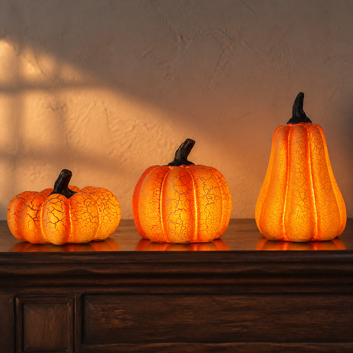 Three Noruva glowing pumpkin lamps in small, medium, and large sizes
